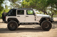 White 2007-2018 Jeep JK 4-Door with DV8 Fastback Hard Top parked on a dirt road with trees in the background