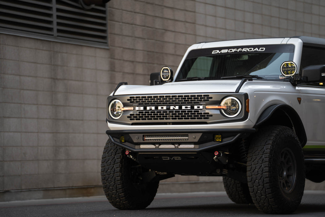 White Ford Bronco off-road vehicle parked in front of a brick wall.