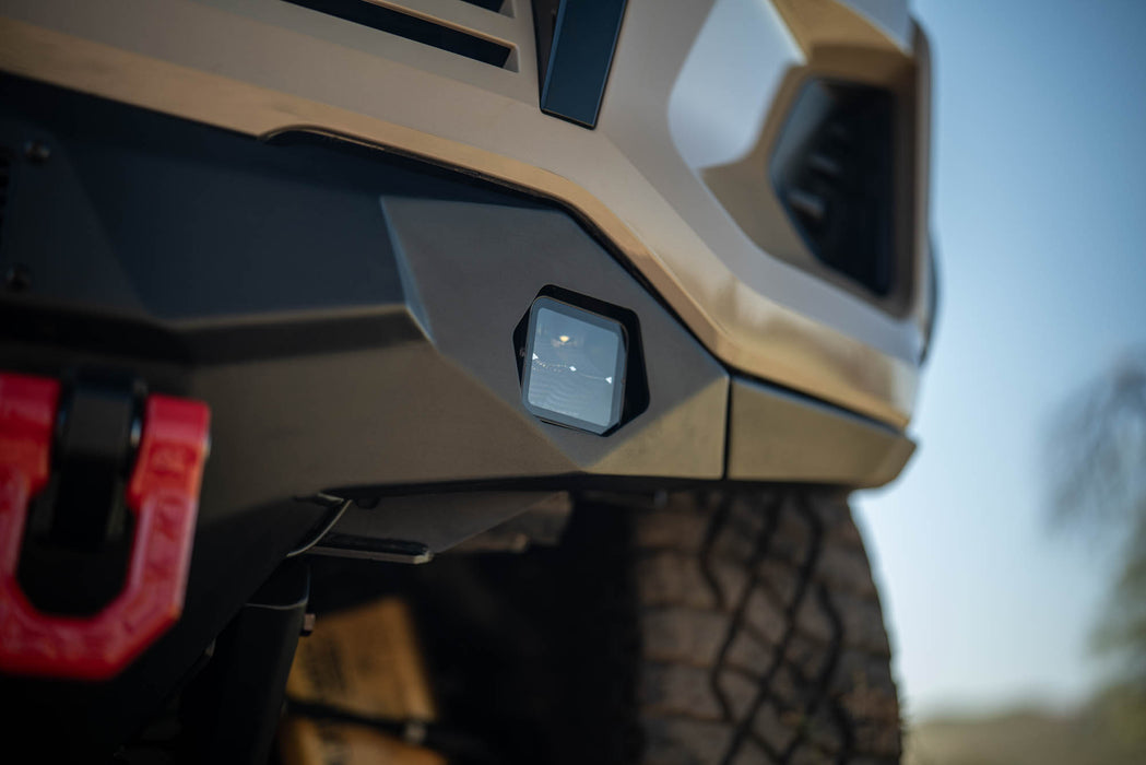 Close-up of a Chevy Colorado ZR2 with Spec Series Front Bumper with a red tow hook and cube light against a blurred natural background