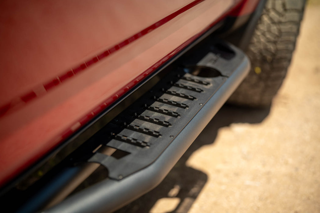 Close-up of a black side step bar on a red vehicle