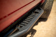Close-up of a black side step bar on a red vehicle