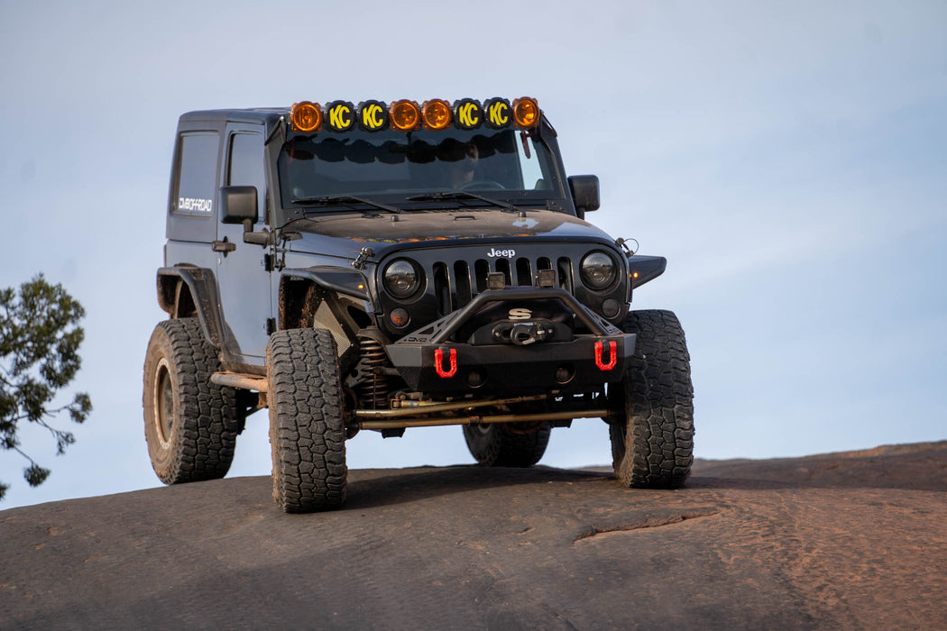 Black Jeep Wrangler JK on a Rock summit with clear sky