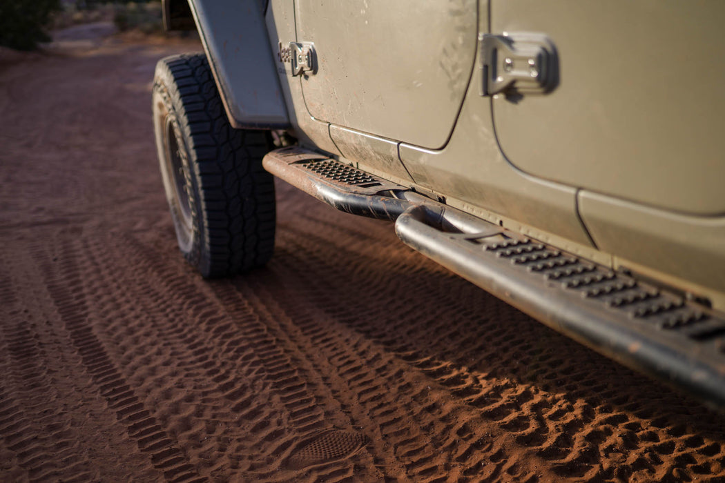 Jeep Gladiator with powder-like dirt covering it's off-road side steps.