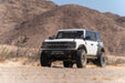 White Bronco with Competition Series front bumper in a bright, arid desert.