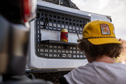 Bronco tailgate molle panels with drink resting on fold-down tray.