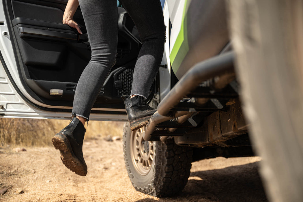 Person stepping out of a vehicle on a dirt road